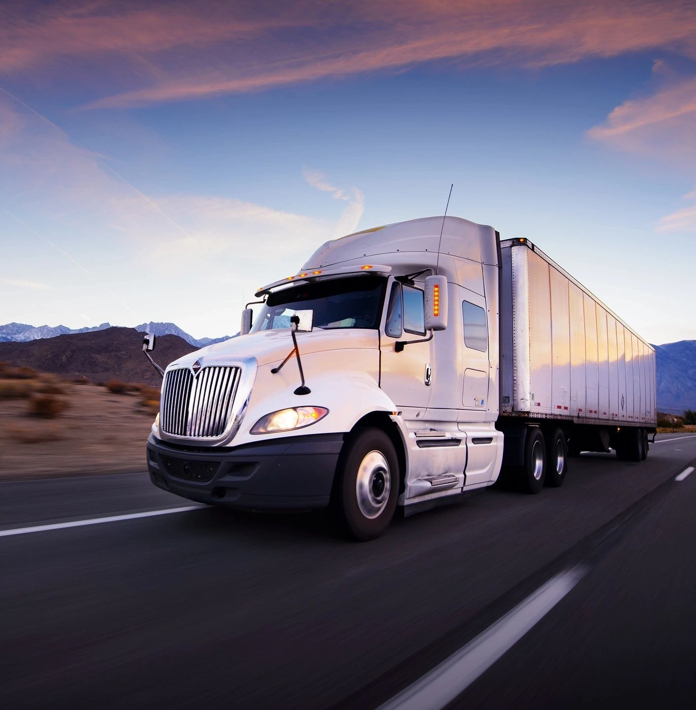 A white semi truck driving down the road.