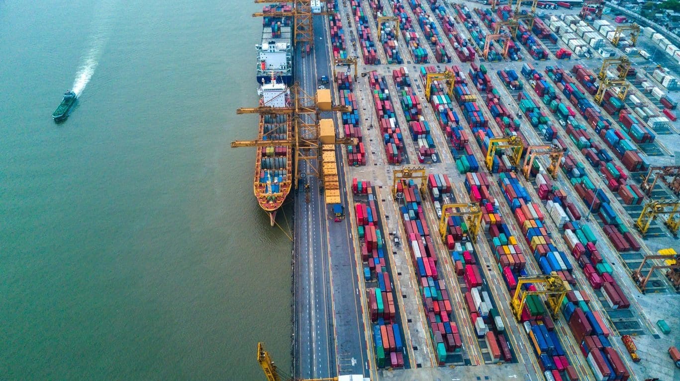 A large ship in the water near some docks.