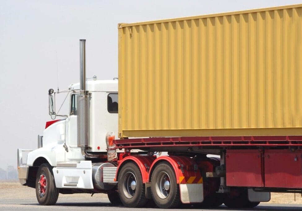 A large truck with a yellow container on the back.