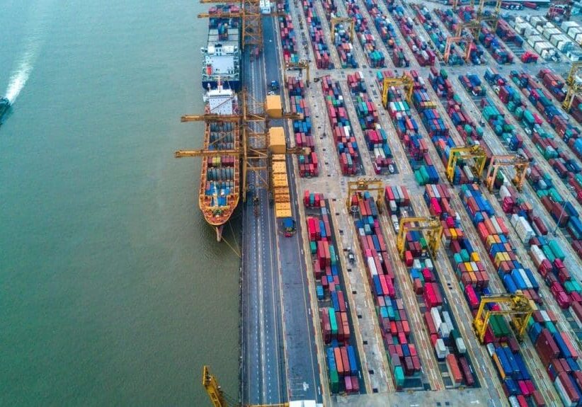 A large ship in the water near some docks.